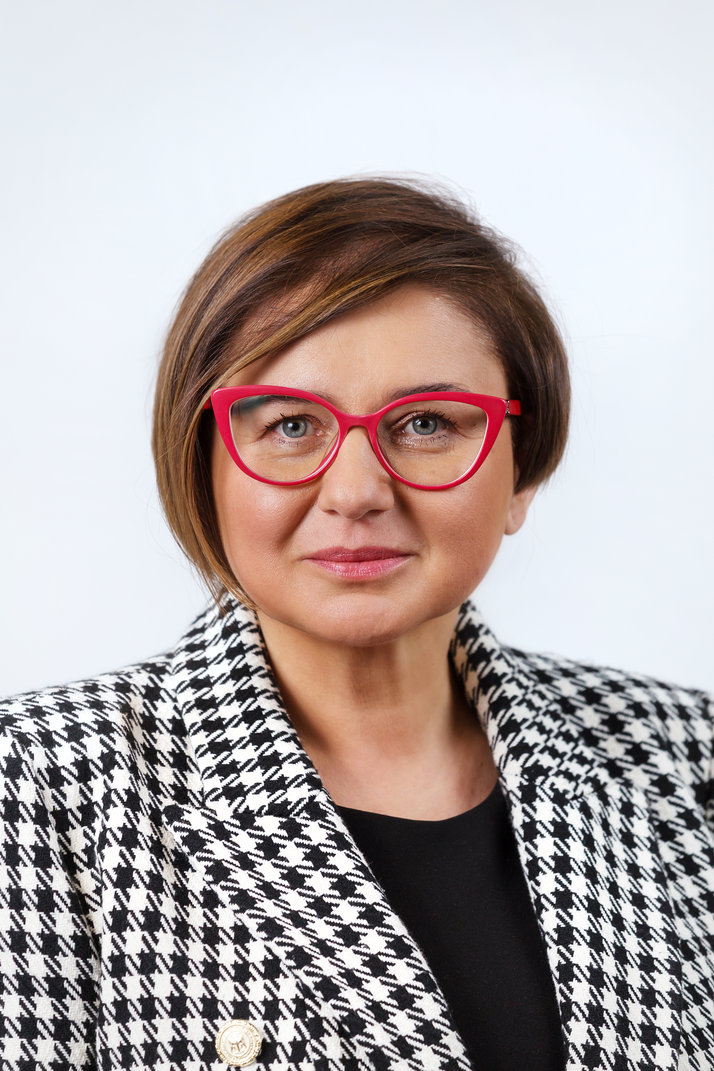 kobieta w okularach w czerwonej oprawce i w marynarce w kratkę