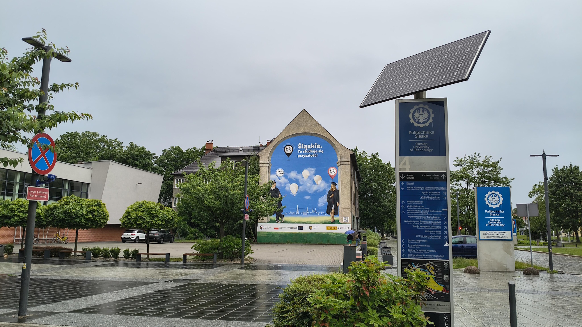 mural na budynku. Pokazuje dwoje ludzi w akademickich strojach