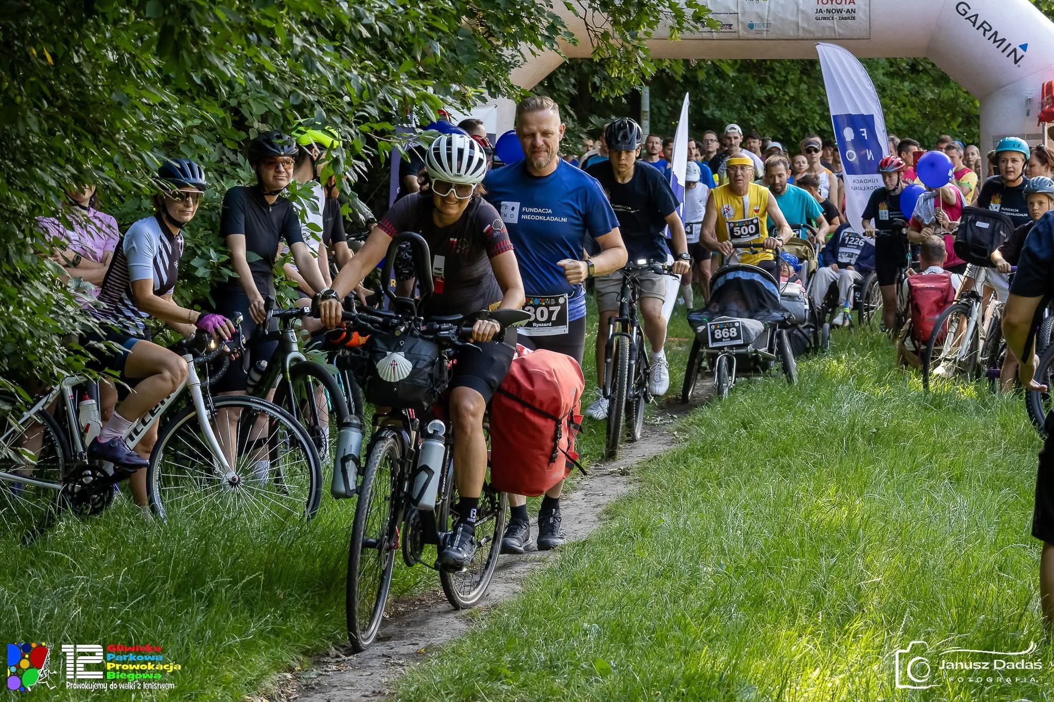 kobieta na rowerze, ludzie obok