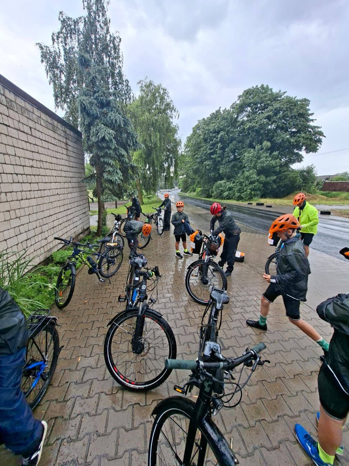 rowerzyści w deszczu przy rowerach