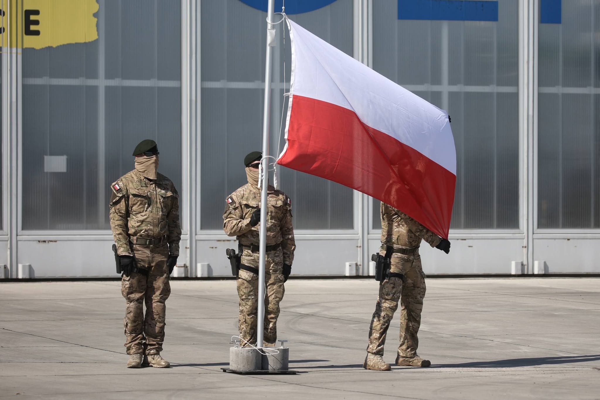 Żołnierze podnoszący flagę Polski na maszt