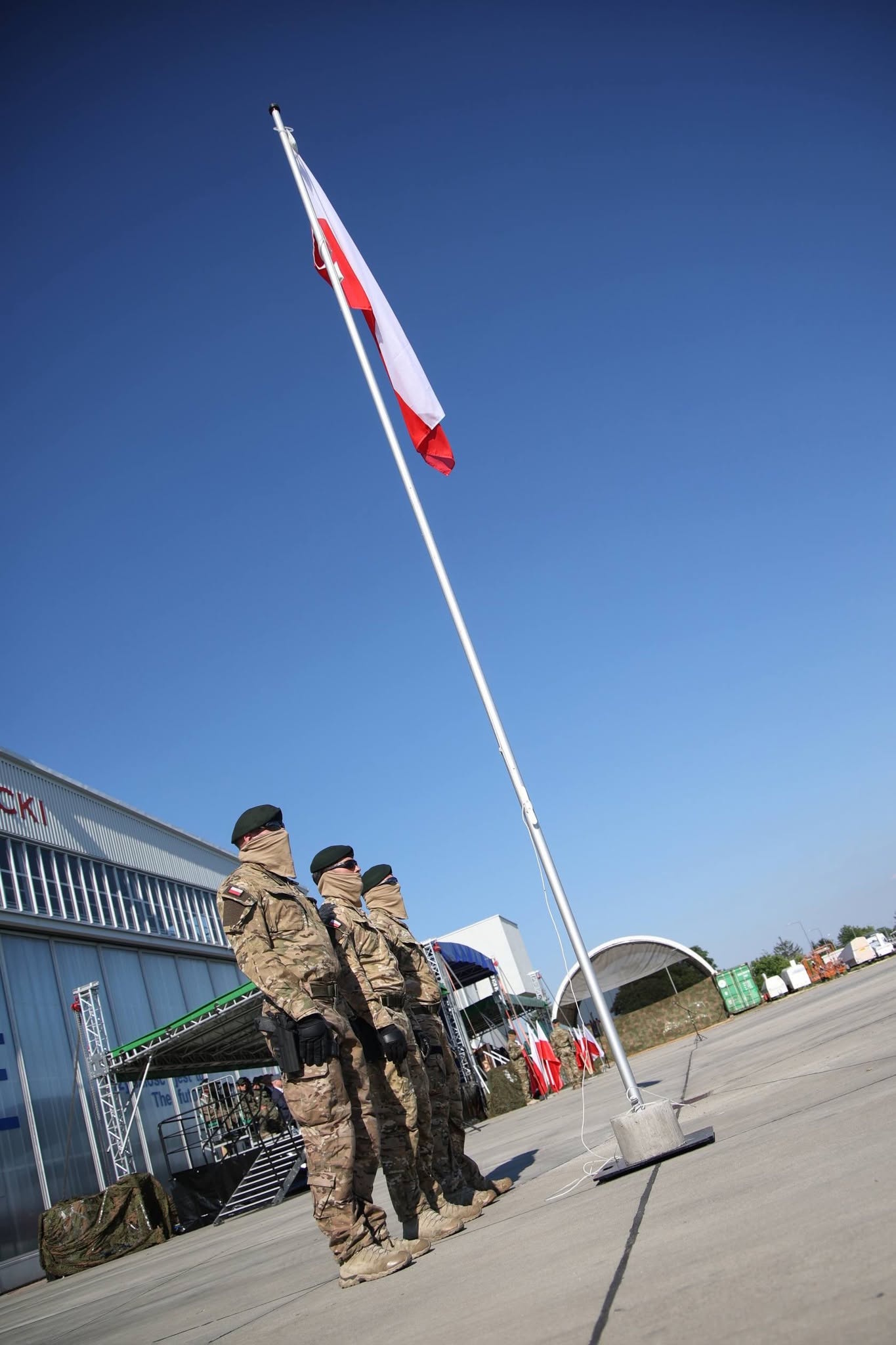 Żołnierze pod masztem z flagą Polski