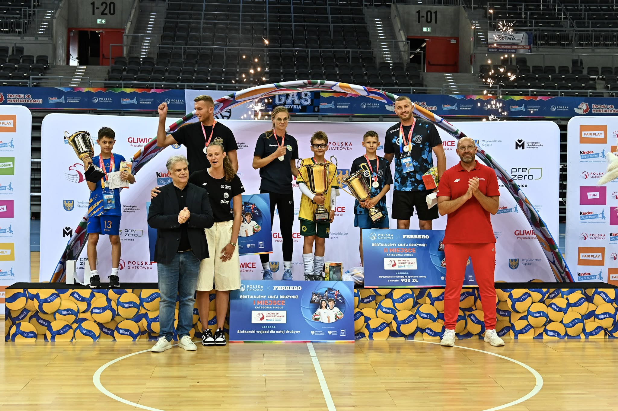 zdjecie grupowe sportowców na podium