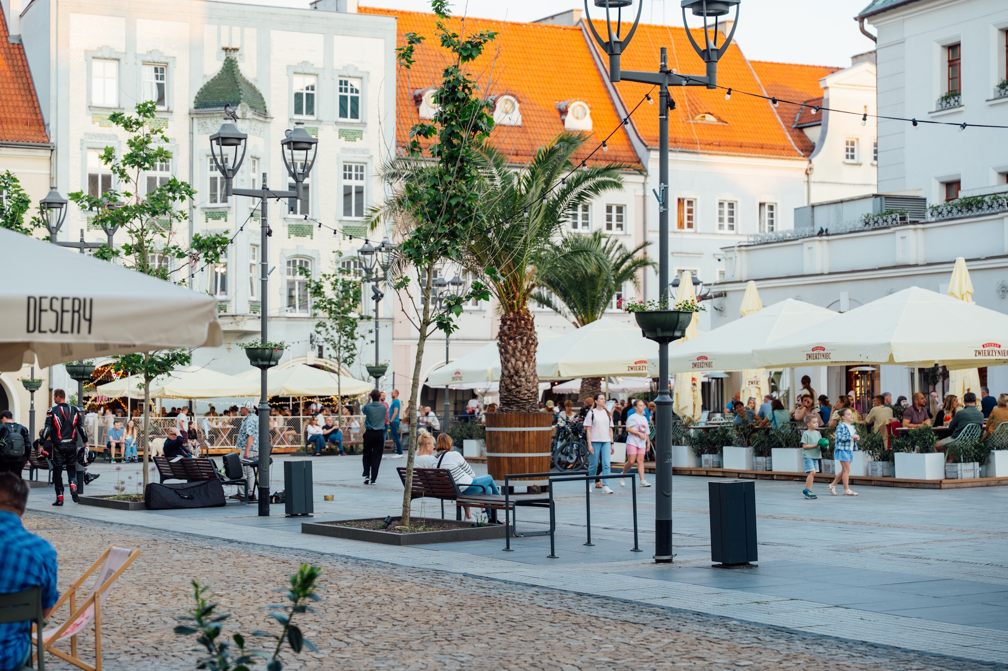 Rybnek z palmami, wokół spacerujący ludzie