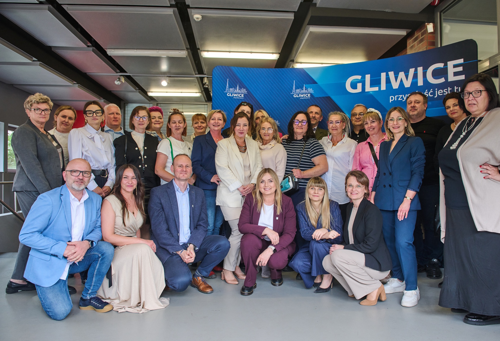 grupa ludzi związanych z pieczą zastępczą pozuje do zdjęcia