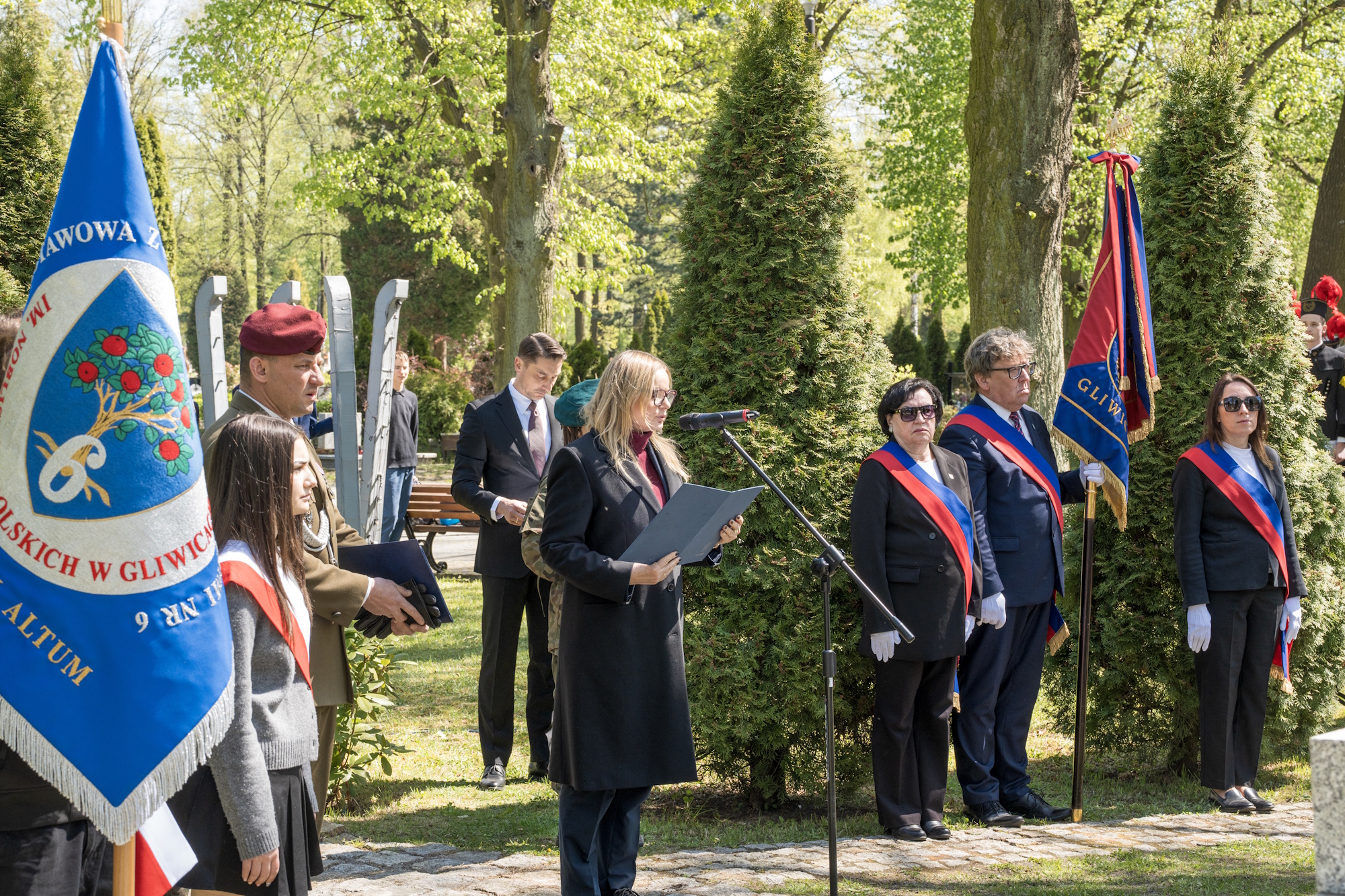 Prezydent przemawia do mikrofonu podczas uroczystości na cmentarzu