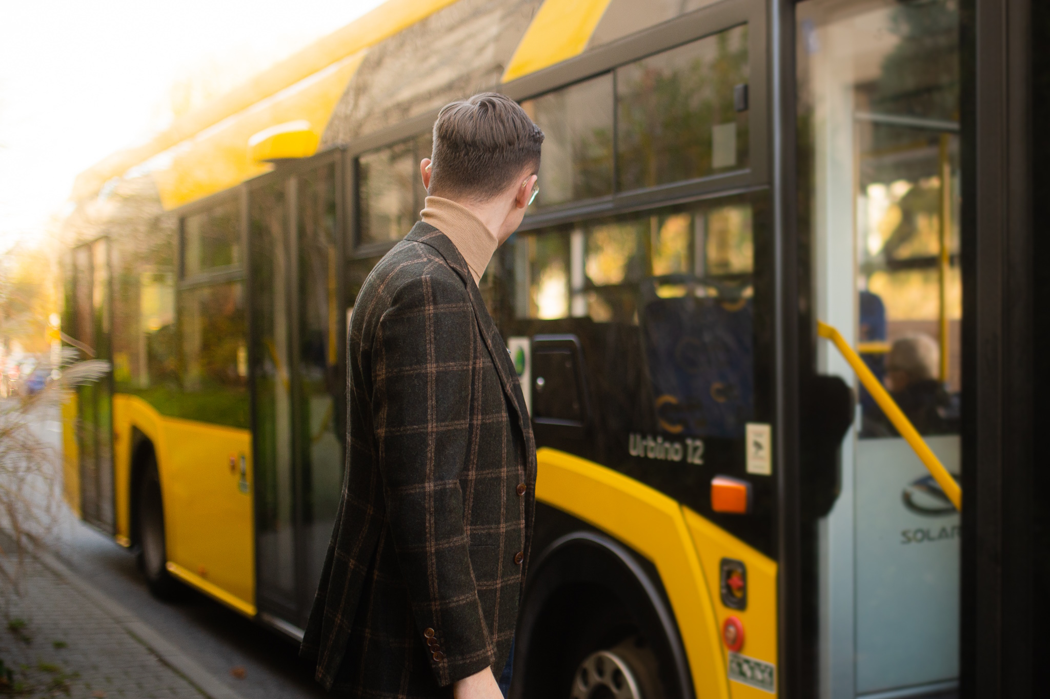 mężczyzna patrzy na żółty autobus