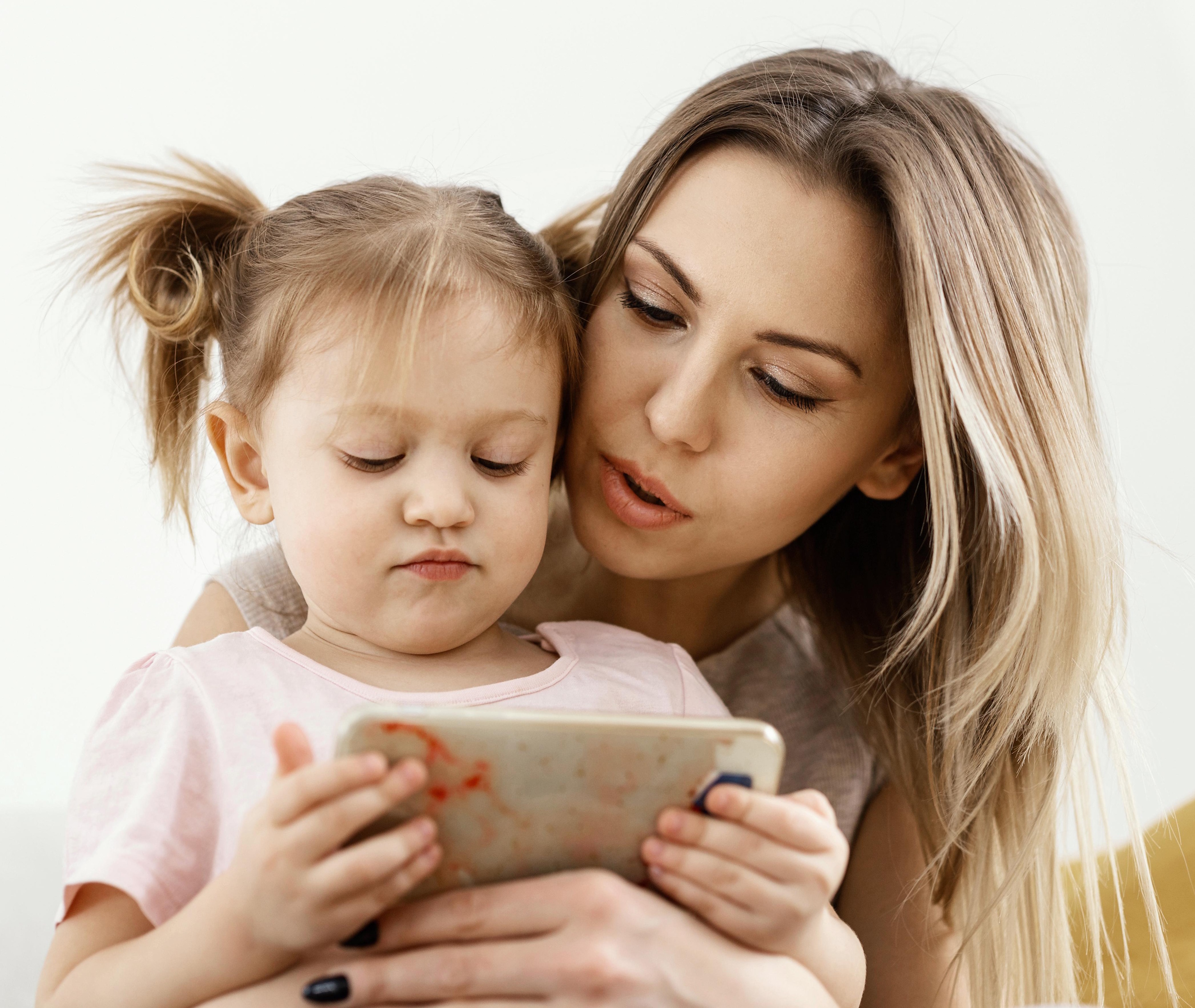 Mama pokazująca małej dziewczynce coś na ekranie tableta