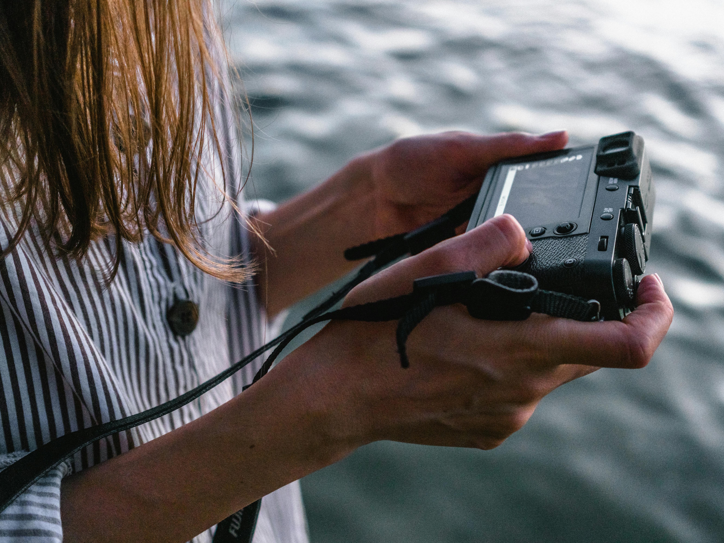 Kobieta trzymająca aparat fotograficzny nad wodą